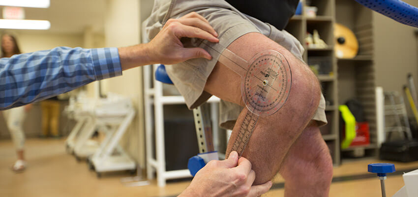 Staff member measuring angle of post-surgery knee